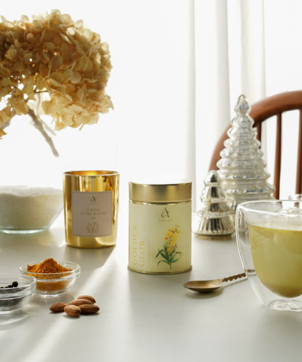 Golden Glow Amba Haldi Latte Mix: a gold candle, honey jar, and spoon for a flavorful and healthy elixir.